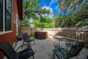 a patio with chairs and a table and a fence at Suite Elliana w/Hot Tub & Outdoor Fireplace! in Fredericksburg +7 photos