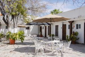 an outdoor patio with tables and chairs and umbrellas at Posada Santa Isabel in Parras de la Fuente