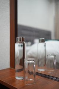 three glass jars and a bottle on a table at Moon and Root in Narendranagar