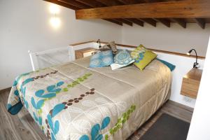 a bedroom with a large bed with blue pillows at Meraki Lofts in El Chalten