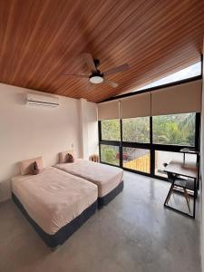 a bedroom with a bed and a ceiling fan at Jungle surf Villa in El Zonte