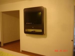 a television on the wall of a room at Bermuda Palms Hotel in San Rafael