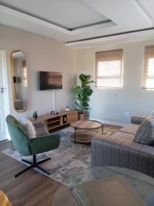 a living room with a couch and a chair at De Guest Suites in Eversdal