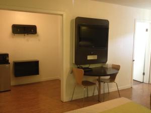 a room with a table and a television on a wall at Bermuda Palms Hotel in San Rafael