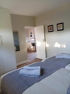 a bedroom with a bed with two towels on it at De Guest Suites in Eversdal