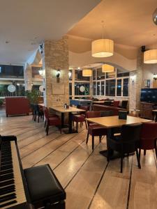 a restaurant with tables and chairs and a piano at Da Beppe in Chiesina Uzzanese