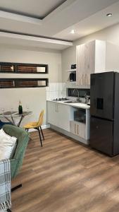 a large kitchen with a table and a refrigerator at De Guest Suites in Eversdal