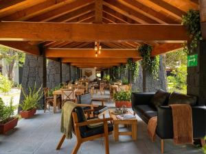 a patio with tables and couches and tables and chairs at Orgánico Hotel Boutique TEPOZTLÁN in Tepoztlán