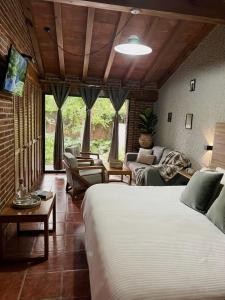 a bedroom with two beds and a living room with a couch at Orgánico Hotel Boutique TEPOZTLÁN in Tepoztlán +46 photos