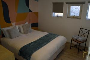 a bedroom with a large bed with a colorful wall at La maison du bienvenu in Namur