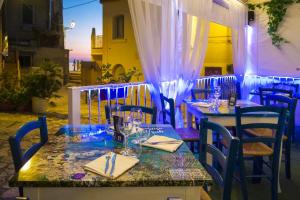 a table and chairs at a restaurant with blue lighting at Mare Fuori Apartment in Tropea