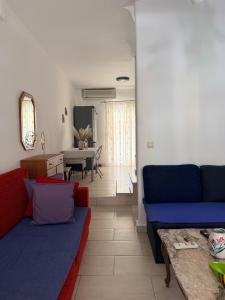 a living room with two blue couches and a table at Kallithea Cove in Kallithea Halkidikis