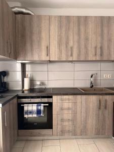 a kitchen with wooden cabinets and a sink at Kallithea Cove in Kallithea Halkidikis +9 photos
