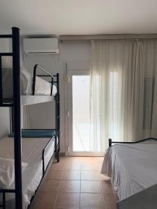 a bedroom with two bunk beds and a window at Kallithea Cove in Kallithea Halkidikis