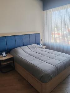 a bedroom with a large bed and a window at STREET MALL Luna N6-3 in Puebla