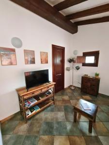 a living room with a flat screen tv and a table at Spartaco Eco Retreat San Pantaleo in San Pantaleo