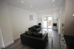 a living room with two couches and a table at Osterley Place - Apt F in Hounslow