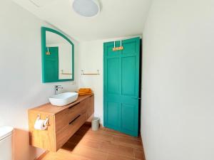 a bathroom with a green door and a sink at Casa Maya by GMHouse Menorca in Cala Blanca +30 photos