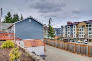 a blue house with a fence and some buildings at Work & Explore Downtown Tacoma! Convenient Condo in Tacoma