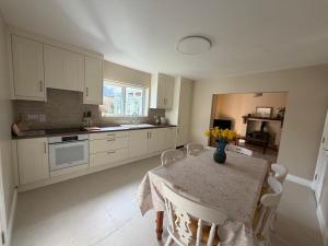 a kitchen with a table with a vase of flowers on it at Glebe cottage in Kinvara +18 photos