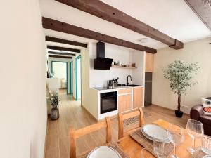 a kitchen and living room with a table and chairs at Casa Maya by GMHouse Menorca in Cala Blanca