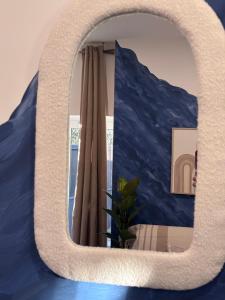 a mirror in a room with a blue wall at Studio Bleu tout équipé au calme proche des commerces in Briord