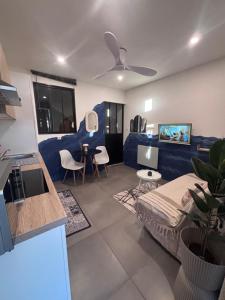 a living room with a blue couch and a table at Studio Bleu tout équipé au calme proche des commerces in Briord