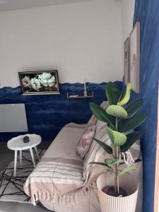 a bedroom with a bed and a potted plant at Studio Bleu tout équipé au calme proche des commerces in Briord +4 photos
