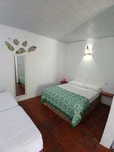 a bedroom with two white beds and a mirror at Pousada Unidos in Jijoca de Jericoacoara +64 photos