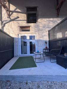 a patio with a table and a chair and a door at Studio Bleu tout équipé au calme proche des commerces in Briord