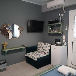 a living room with a chair and a mirror at Mulberry house in Elafonisos