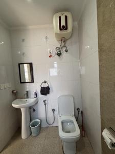 a small bathroom with a toilet and a sink at The Huddle - Dawn in Dehradun +9 photos