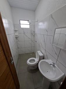 a white bathroom with a toilet and a sink at Cachoeira e Pousada dos Pássaros in Presidente Figueiredo +3 photos