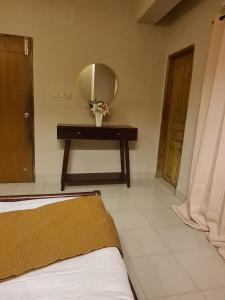 a bedroom with a table with a mirror and a bed at Couple room, attached balcony in Safipur
