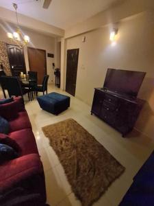 a living room with a couch and a tv at Couple room, attached balcony in Safipur