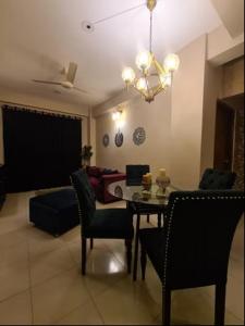 a living room with a table and chairs and a couch at Couple room, attached balcony in Safipur +4 photos
