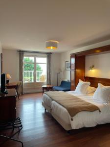 a hotel room with a large bed and a window at Hotel Le Bellevue, Demeures & Chateaux in Villerville
