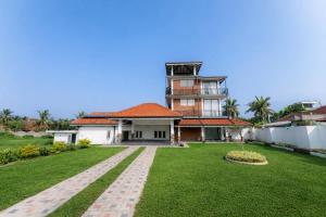 a house with a grass yard in front of it at Peak Heaven Apartments in Negombo