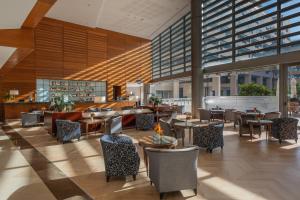 a restaurant with tables and chairs and windows at Eurostars Grand Marina Hotel GL in Barcelona