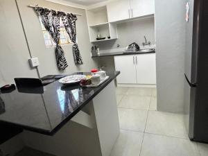 a kitchen with a black counter top in a room at Primkop Cottage in White River
