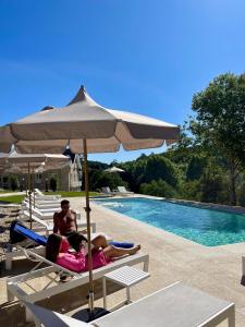 two people laying on lounge chairs under an umbrella next to a pool at Villa Boutique 1880-Romantic Historic Boutique Hotel with Outdoor Jacuzzi in San Salvador +60 photos