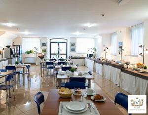 a restaurant with tables and chairs and a kitchen at Nazareth Residence in Viterbo