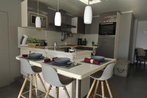 a kitchen with a table with chairs and a counter top at Le Clos Sigebert in Libramont