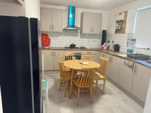 eine Küche mit Tisch, Stühlen und Kühlschrank in der Unterkunft SAMAz in Manchester