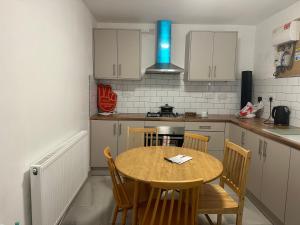 eine kleine Küche mit einem Holztisch und Stühlen in der Unterkunft SAMAz in Manchester
