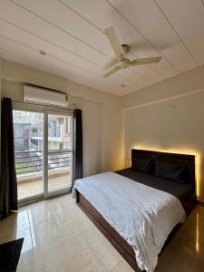 a bedroom with a bed and a ceiling fan at The Huddle - Dusk in Dehradun