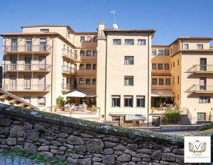 a building with a stone wall in front of it at Nazareth Residence in Viterbo