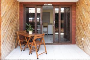 a patio with a table and two chairs and a plant at Pipas Ocean by Pipa Centro in Pipa