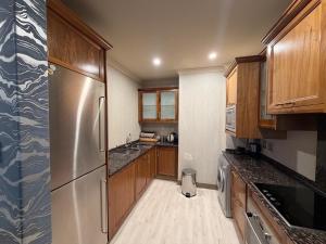 a kitchen with wooden cabinets and a stainless steel refrigerator at Michelangelo Towers in Johannesburg