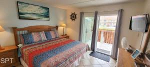 a bedroom with a bed and a sliding glass door at Fiesta Sol #110 in South Padre Island +69 photos